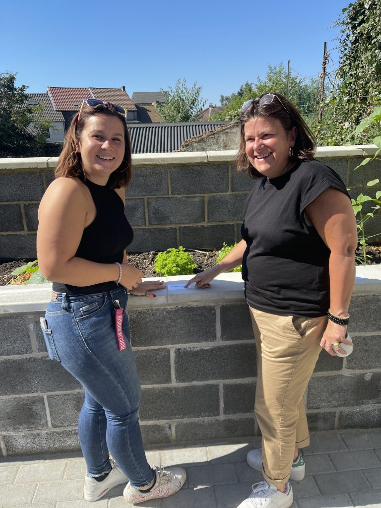 Alicia Monard et une autre personne regarde les inscriptions en braille dans le jardin.