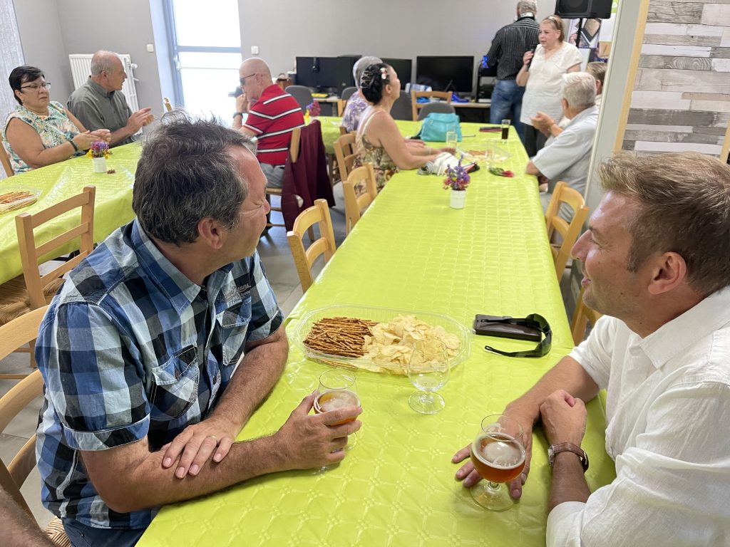 Vue de l'ambiance et des tables avec les participants de dos.