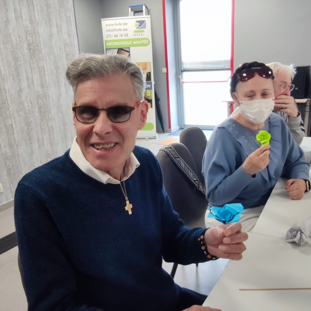 Jean-Pierre prend la pose avec sa fleur, nathalie ne arrière plan