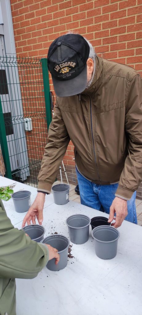 Roberto met du terreau dans un pot