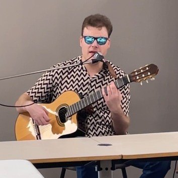 Alexandre joue de la guitare et chante lors d'un club HVFE.