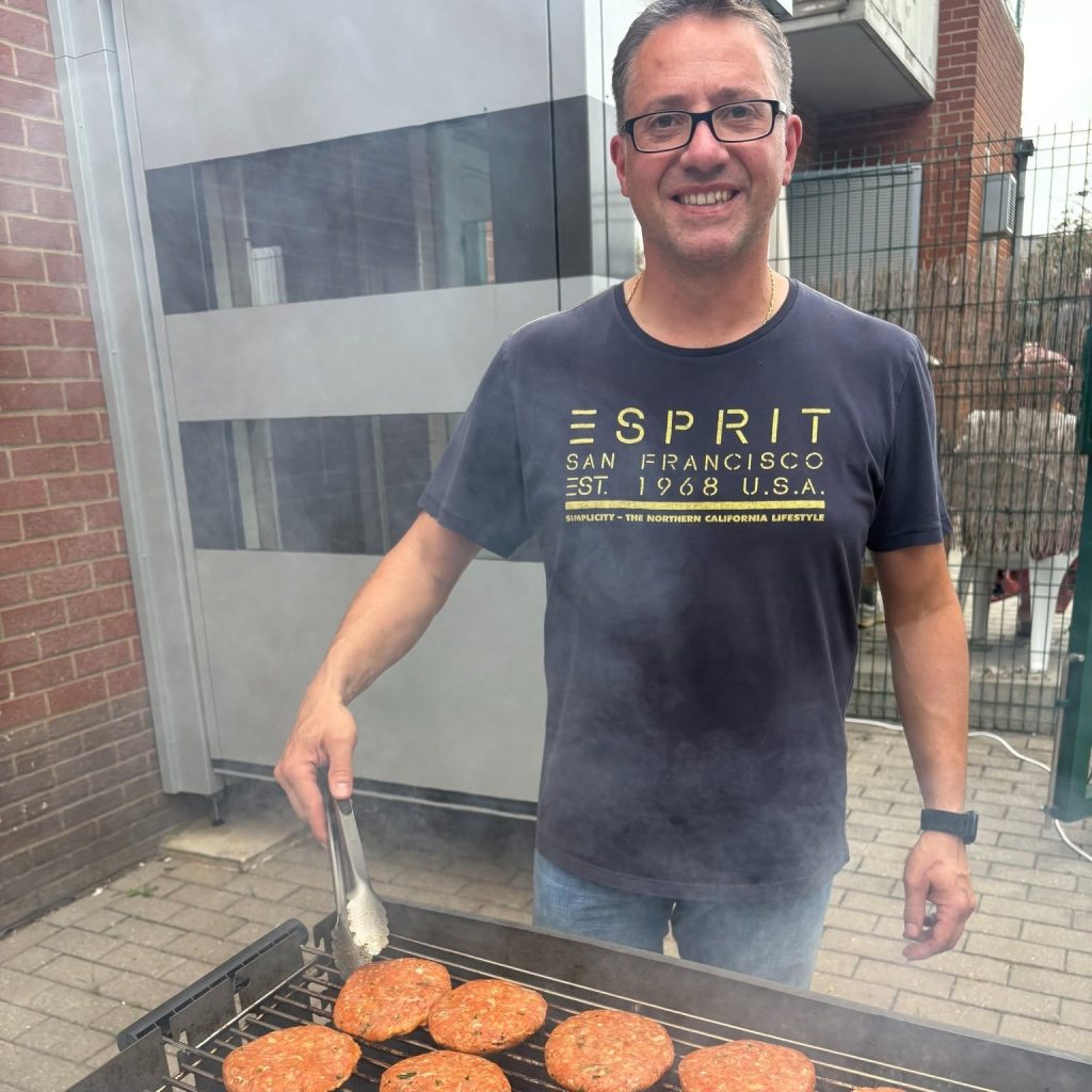 Franck prépare les hamburgers au barbecue