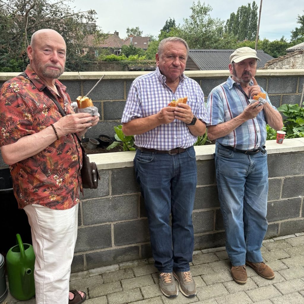 Francis, José et Alex discutent ensemble en savourant leur pain hamburger